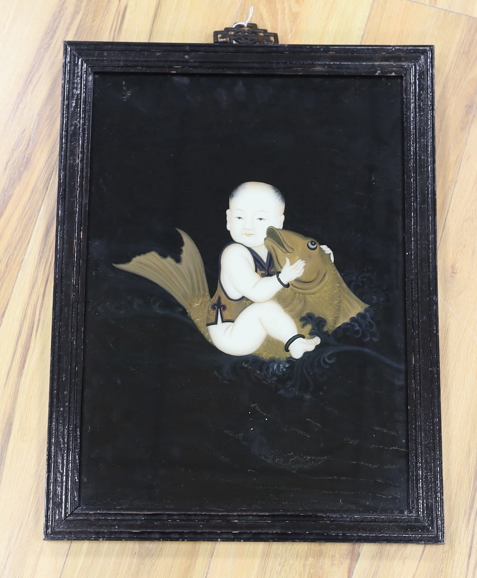 A Chinese reverse painting on glass of a boy and a carp, 52 x 37.5cm